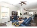 Bright living room featuring a comfortable blue sofa, hardwood floors, and large windows at 7024 Jane Parks Way, Charlotte, NC 28217