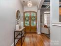 Warm and inviting foyer with wood flooring, decorative mirror and a view to a living area at 705 Woburn Abbey Dr, Fort Mill, SC 29715