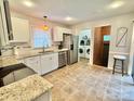 Efficient kitchen with white cabinets, granite countertops, stainless steel appliances, and adjacent laundry at 7133 Tall Tree Ln, Charlotte, NC 28214
