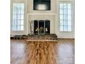 Cozy living room featuring a fireplace with a TV above it and wood flooring at 7133 Tall Tree Ln, Charlotte, NC 28214