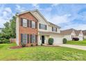 A charming home with a brick accent, well-kept lawn, and a convenient two-car garage at 720 Reigate Rd, Charlotte, NC 28262