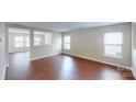 Bright, airy living room featuring hardwood floors, neutral walls, and ample natural light from multiple windows at 8139 Deodora Cedar Ln, Charlotte, NC 28215