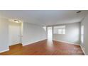 Spacious living room with hardwood floors, neutral color scheme, and an open layout flowing into other areas at 8139 Deodora Cedar Ln, Charlotte, NC 28215