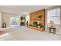 Bright living room features a brick fireplace, sliding glass door, and neutral carpet at 841 12Th Nw Ave, Hickory, NC 28601
