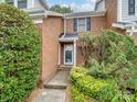 Inviting townhouse entrance with a brick facade and lush green landscaping at 9121 Kings Canyon Dr, Charlotte, NC 28210