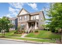 Attractive two-story home with brick and siding facade, complemented by lush landscaping and a inviting front porch at 915 Claires Creek Ln, Davidson, NC 28036