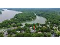 Scenic aerial view of a home nestled among lush trees with lake access, marked with an arrow for emphasis at 10449 Quiet Bay Ct, Charlotte, NC 28278