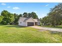 Single story home with garage and driveway set among mature trees and a green lawn at 105 Saddlewood Ln, Statesville, NC 28625