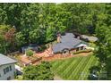 A captivating aerial view of a brick home surrounded by mature trees, patio, garden, and lush backyard at 1226 Tarrington Ave, Charlotte, NC 28205