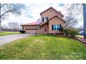 Inviting home with a red metal roof, well-manicured lawn, and a driveway leading to the attached garage at 1228 Hidden Creek Cir, Hickory, NC 28602