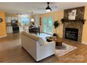 A cozy living room features a stone fireplace, hardwood floors, and an open floor plan to the kitchen at 1228 Hidden Creek Cir, Hickory, NC 28602