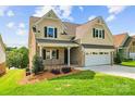 Side view of a two-story home with a brick porch and attached two-car garage on a sunny day at 1280 Winged Foot Dr, Denver, NC 28037