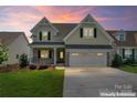 Charming two-story home featuring manicured lawn, brick accents, two-car garage and inviting front porch at 1280 Winged Foot Dr, Denver, NC 28037