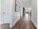 Hallway with gleaming hardwood floors, crisp white trim, and a glimpse of a cozy living area at 1280 Winged Foot Dr, Denver, NC 28037