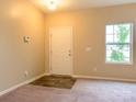 Inviting entryway featuring plush carpet, modern flooring accent, neutral paint, and natural light from the window at 13022 Hill Pine Rd, Midland, NC 28107