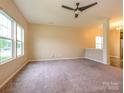 Spacious living room with carpet, large windows offering plenty of natural light, and a ceiling fan at 13022 Hill Pine Rd, Midland, NC 28107