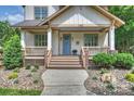 Inviting front porch with wooden railings, brick accents, and manicured landscaping leading to a bright blue front door at 1315 Charles Ave, Charlotte, NC 28205