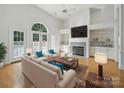 Bright living room with hardwood floors, fireplace, built-in shelves, and views of the pool at 1340 Canter Ln, York, SC 29745