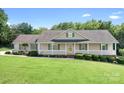 Inviting home showcasing a spacious front porch with white railing and green shutters at 136 Barringer Dr, Statesville, NC 28625