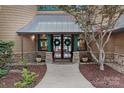 Elegant home entrance with stone accents, wreath decorated doors, and manicured landscaping at 145 Hunters Pointe Ln, Mooresville, NC 28117