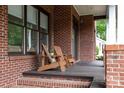 Relaxing front porch featuring chairs and brick flooring at 1833 The Plz, Charlotte, NC 28205