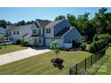 Inviting two-story home featuring a lush lawn, mature trees, and a two-car garage at 2035 Beacon Ave, Monroe, NC 28110