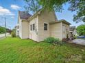 Image of the back exterior of the home, surrounded by green grass at 211 S Rowan Ave, Spencer, NC 28159