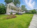 Exterior view of a well-kept lawn with a charming house and inviting front porch at 211 S Rowan Ave, Spencer, NC 28159