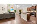 Open-concept living space with hardwood floors, a modern kitchen, and a vaulted ceiling at 225 Tasman Dr, Mount Holly, NC 28120