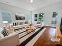 Bright living room with a striped rug, white furniture, and many windows at 27415 Cinderella Cir, Lancaster, SC 29720