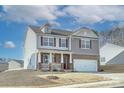 Two-story home with a brick and siding exterior, attached two-car garage and landscaping on a sunny day at 427 Carolina Hemlock Dr, Locust, NC 28097
