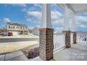 View from the covered front porch showing brick columns and white railings at 427 Carolina Hemlock Dr, Locust, NC 28097
