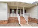 Inviting front porch with brick steps, white railings, and a covered entryway offering curb appeal at 5129 Whitetail Ct, Crouse, NC 28033