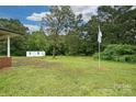 Expansive backyard featuring a large shed, flagpole, and ample green space for outdoor activities at 5222 Sikes Mill Rd, Monroe, NC 28110
