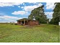 Rear exterior featuring a covered porch, brick facade, and spacious yard at 5222 Sikes Mill Rd, Monroe, NC 28110