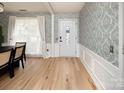 Welcoming entryway with wood floors, decorative wallpaper, and front door at 5741 Bentgrass Run Dr, Charlotte, NC 28269
