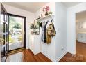 Bright entryway with wood floors, a decorative shelf, and a coat rack, leading into the home at 5809 Sharon Rd # G, Charlotte, NC 28210