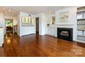 Inviting living room with hardwood floors, a fireplace, built-in cabinets, and open access to the kitchen at 5809 Sharon Rd # G, Charlotte, NC 28210