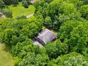 Aerial view of a single-Gathering home surrounded by dense, mature trees at 7725 Whitmire Ln, Mint Hill, NC 28227