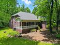 Brick house with a porch and lush green lawn at 7725 Whitmire Ln, Mint Hill, NC 28227