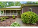 Charming brick home with a covered porch and well-manicured landscaping at 7725 Whitmire Ln, Mint Hill, NC 28227