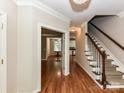Elegant foyer with gleaming hardwood floors, staircase, and views of dining room at 8218 Houston Ridge Rd, Charlotte, NC 28277
