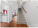 Bright entryway features wood floors, staircase with wood railing, and open view into the kitchen and living spaces at 945 Heritage Pkwy, Fort Mill, SC 29715