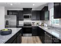 Modern kitchen featuring stainless steel appliances, dark cabinets, and granite countertops at 10124 Florentine Way, Charlotte, NC 28214