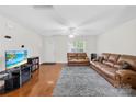 Spacious living room featuring hardwood floors, a ceiling fan, and ample natural light from a window at 1023 Valley Ridge Rd, Charlotte, NC 28214