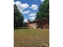 Exterior view of a brick home featuring a screened-in porch and a spacious backyard at 10500 Bethel Church Rd, Midland, NC 28107
