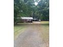 Spacious property with a single-story home, open carport, and large front yard with mature trees at 10500 Bethel Church Rd, Midland, NC 28107