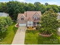 Aerial view of a beautifully landscaped home with mature trees and a long driveway, enhancing curb appeal at 10703 Back Ridge Rd, Charlotte, NC 28277