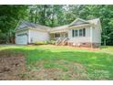 Quaint single-story home boasting a welcoming front porch and lush green lawn at 121 Jefferson Dr, Locust, NC 28097