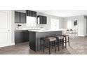Stylish kitchen featuring dark cabinetry, stainless steel appliances, and a center island with barstool seating at 12109 Beaux Art Ln, Charlotte, NC 28214